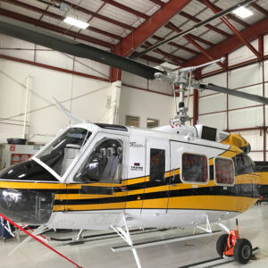 A Bell 205A1 sits in a hangar
